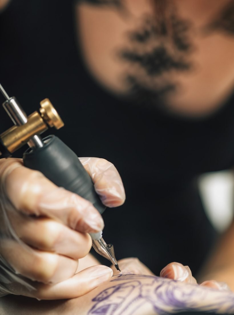 Tattoo Machine Close Up. Tattoo Artist Creating Tattoo on a Man's Arm